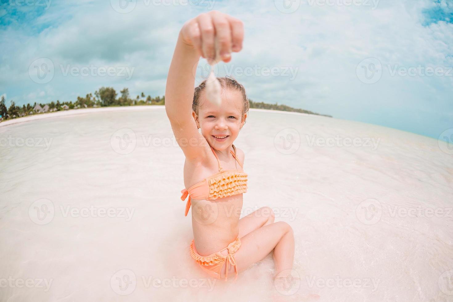 skön liten flicka på strand har roligt. rolig flicka njut av sommar semester. foto