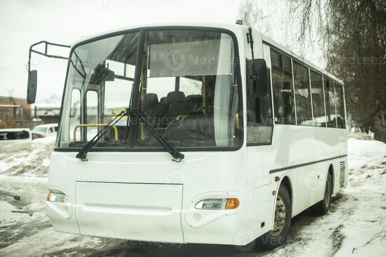 vit buss i parkering massa. offentlig transport i vinter. foto