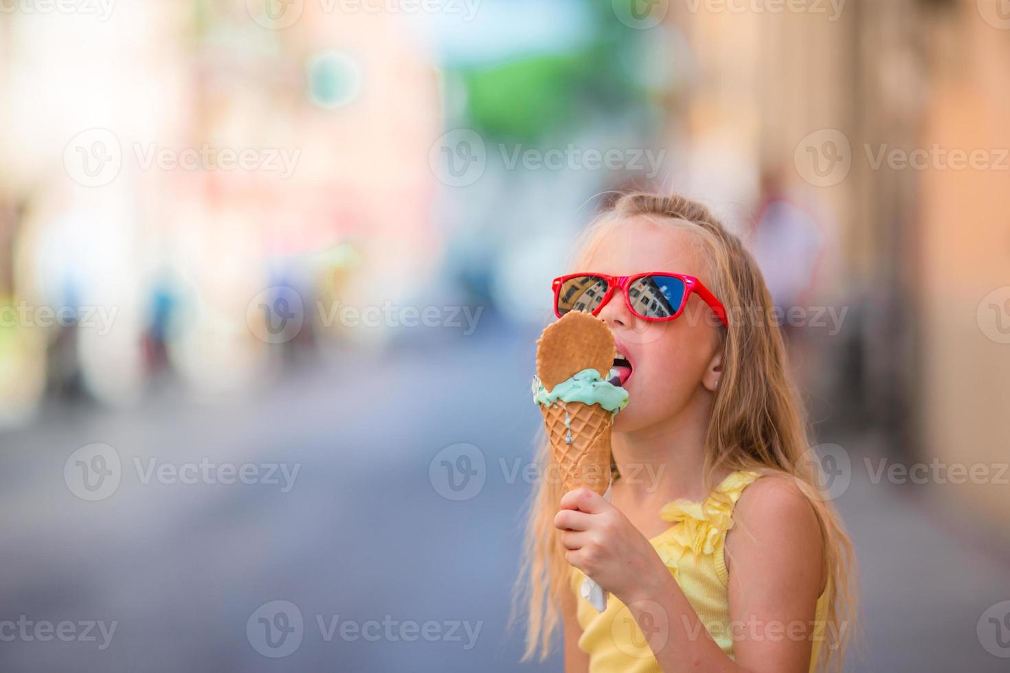 förtjusande liten flicka äter glass utomhus på sommar. söt unge njuter verklig italiensk gelato nära gelateria i rom foto