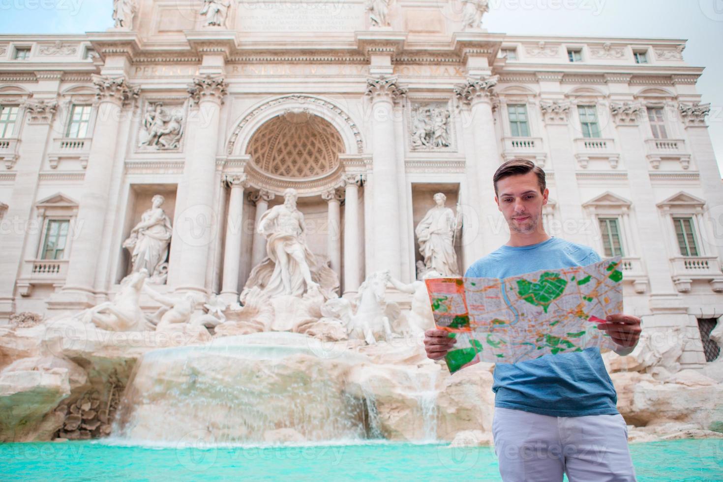 ung man med turistiska stadskarta nära fontan di trevi, rom, Italien. foto