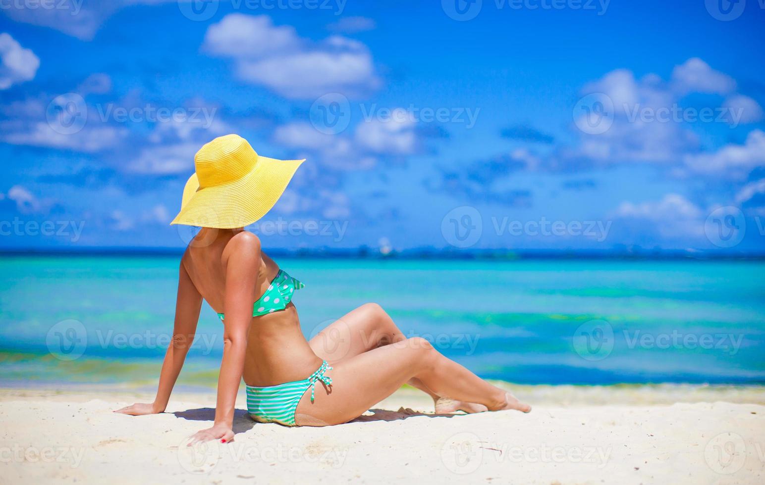 skön kvinna i gul hatt på vit tropisk strand foto