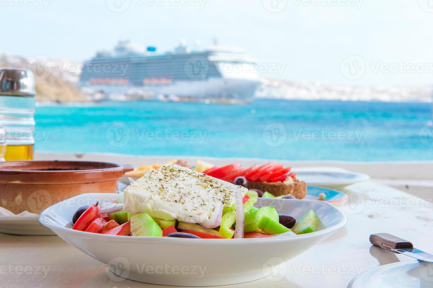 traditionell lunch med utsökt färsk grekisk sallad och brusketa eras för lunch på utomhus- Kafé med se på de hav foto