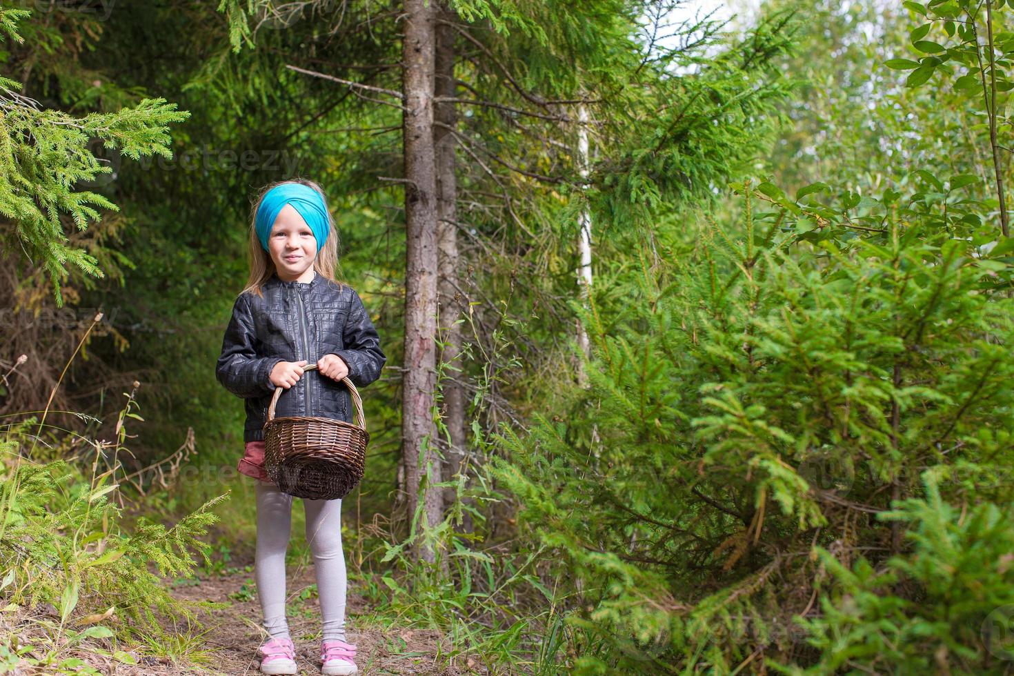 liten Lycklig flicka plocka upp svamp i höst skog foto