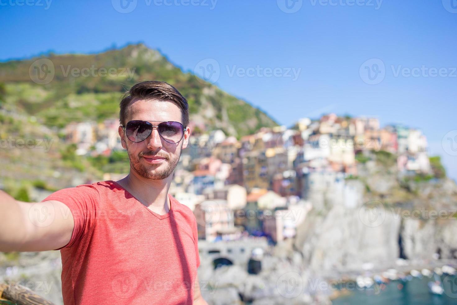 ung turist i solglasögon tar selfie med naturskön se av manarola, cinque terre, liguria, Italien foto