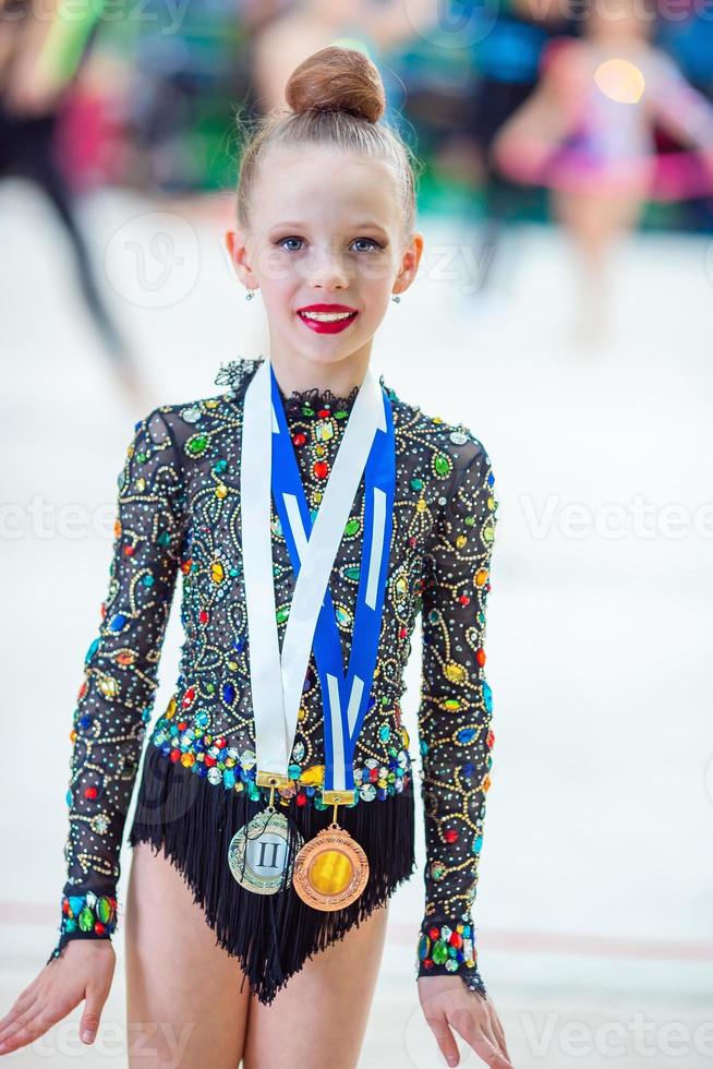 skön liten gymnast Träning på de matta och redo för tävlingar foto