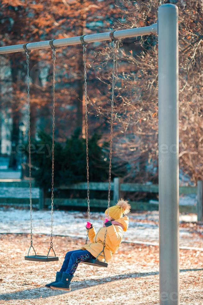 förtjusande liten flickor gungor på en gunga i central parkera på ny york stad foto