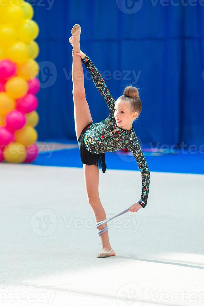 skön liten gymnast flicka på de matta på de konkurrens foto