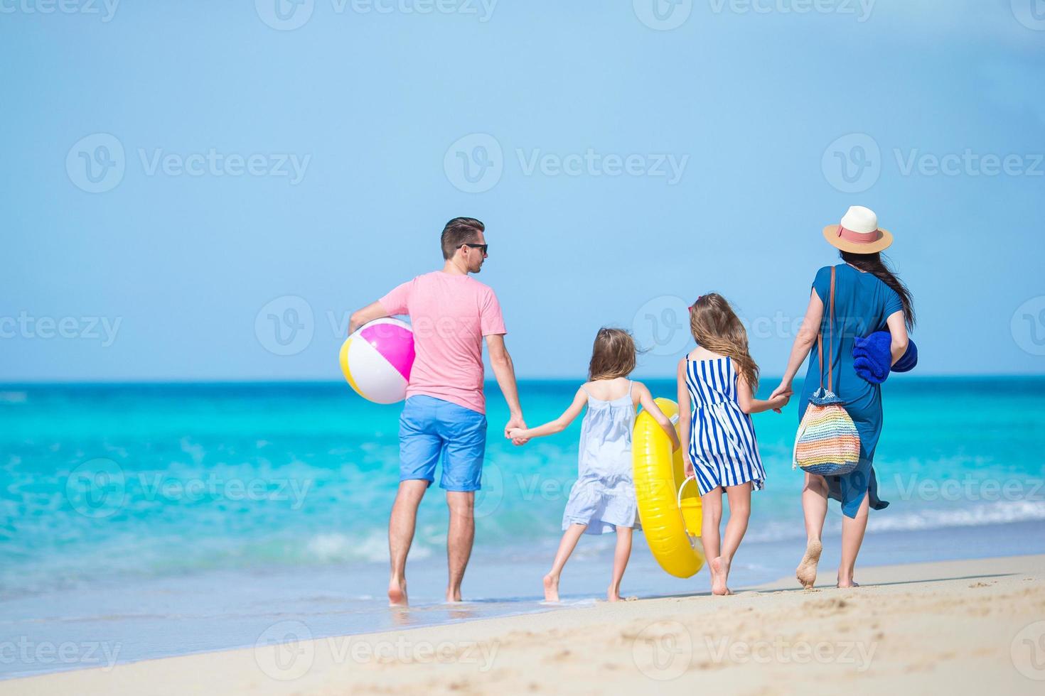 ung familj på semester ha en massa av roligt tillsammans. föräldrar och barn gående till simma foto