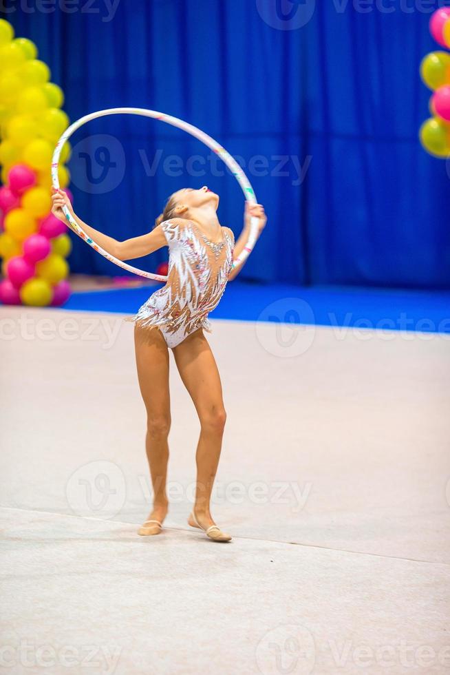 skön liten gymnast flicka på de matta på de konkurrens foto