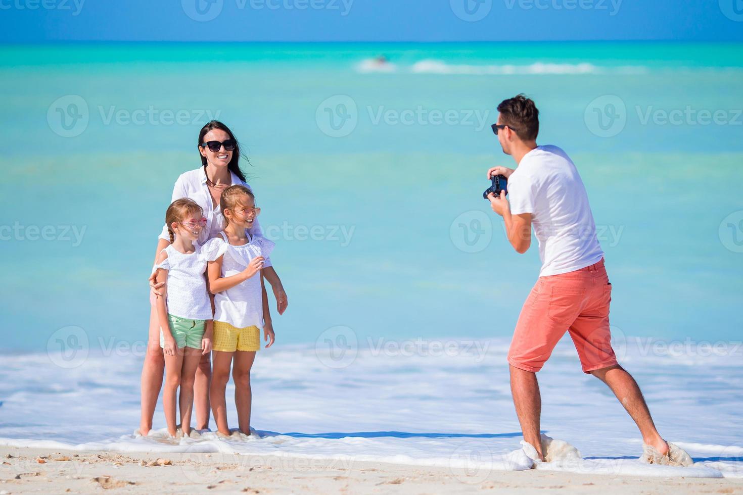 familj av fyra tar en selfie Foto på deras strand högtider. familj strand semester