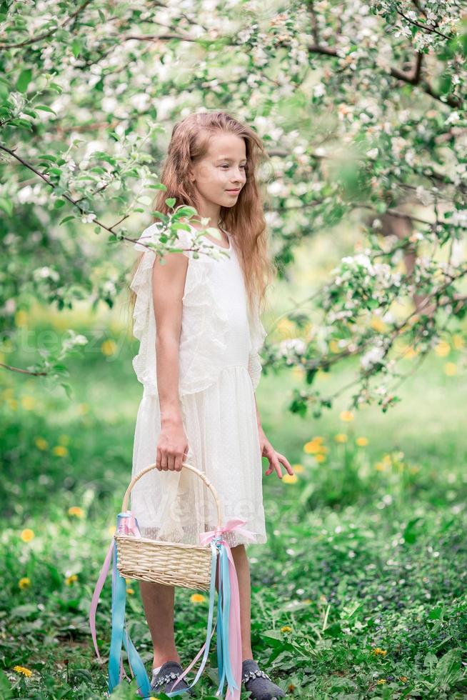 förtjusande liten flicka i blomning äpple trädgård på skön vår dag foto