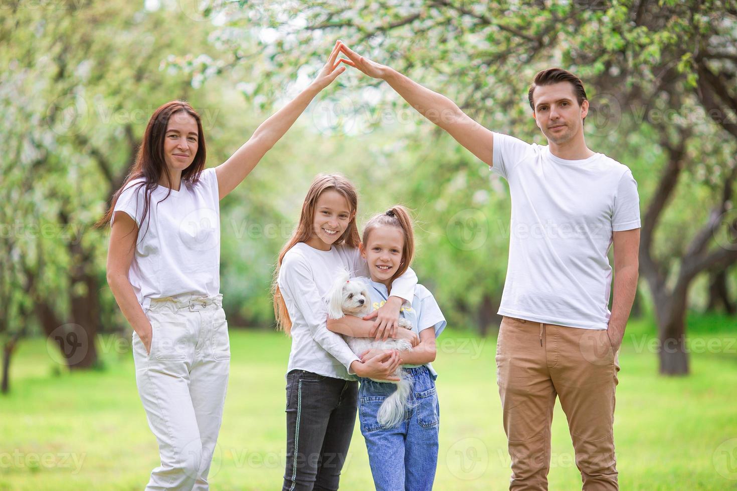 förtjusande familj i blomning körsbär trädgård på skön vår dag foto