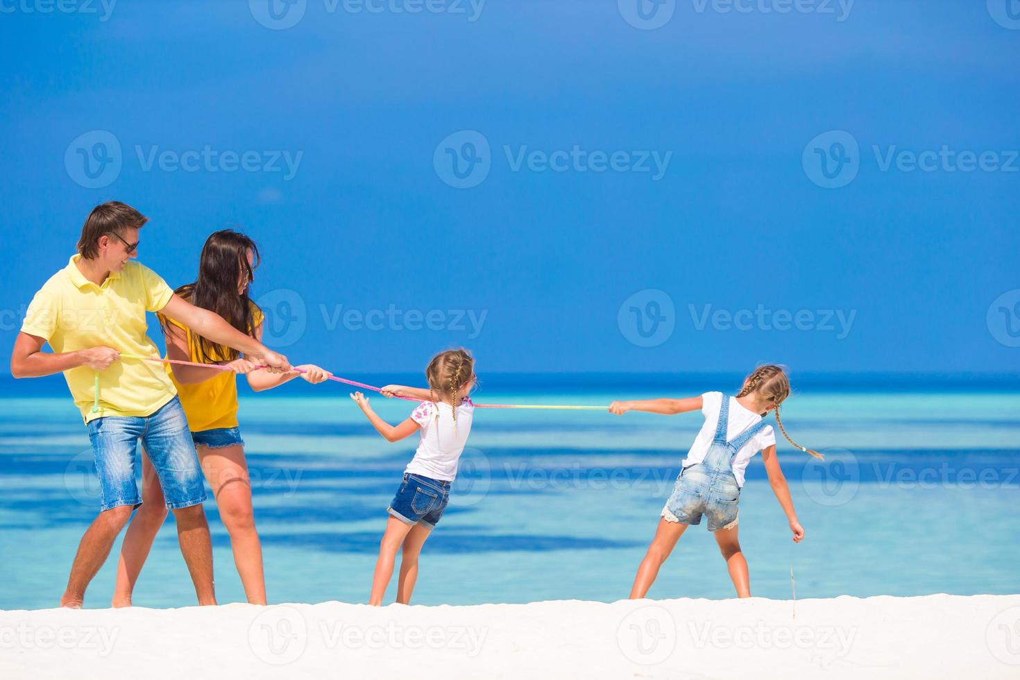 lycklig familj att ha kul på den vita stranden foto