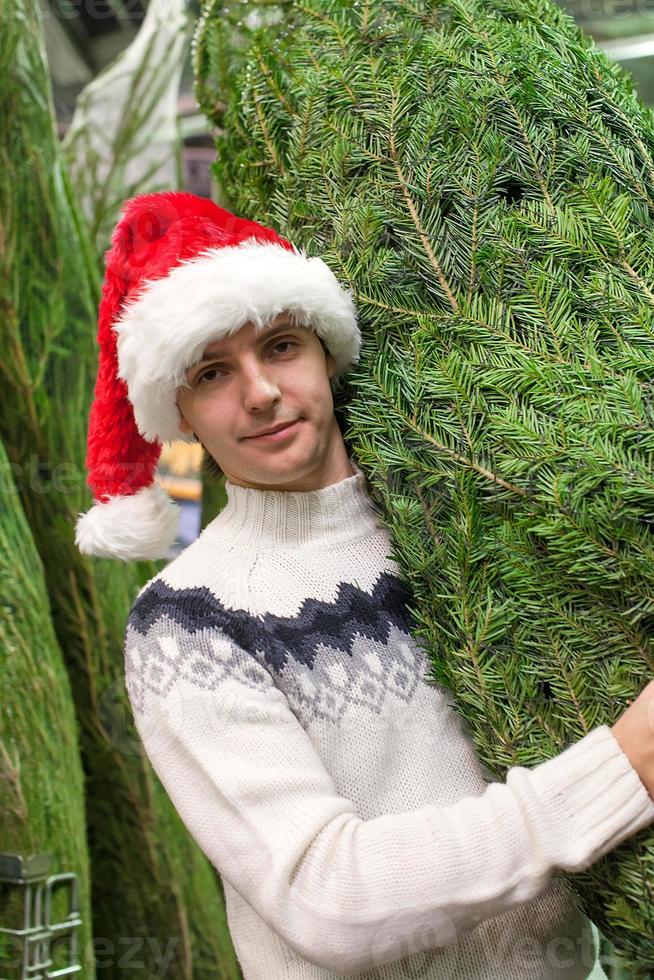 ung man uppköp en jul träd i de Lagra foto
