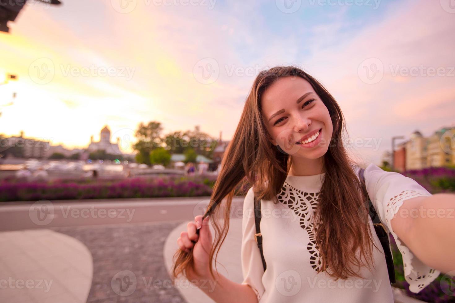 ung flicka framställning selfie och har roligt i de parkera. livsstil selfie porträtt av ung positiv kvinna har roligt och tar selfie. begrepp roligt med ny trender och teknologi. foto