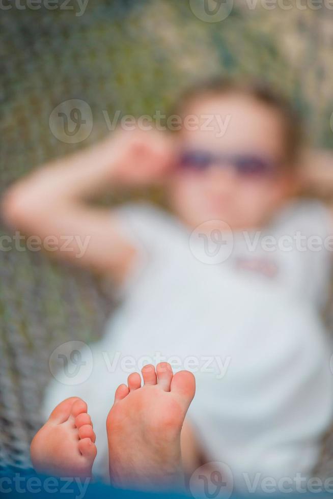 förtjusande liten flicka i hängmatta utomhus- på de strand foto