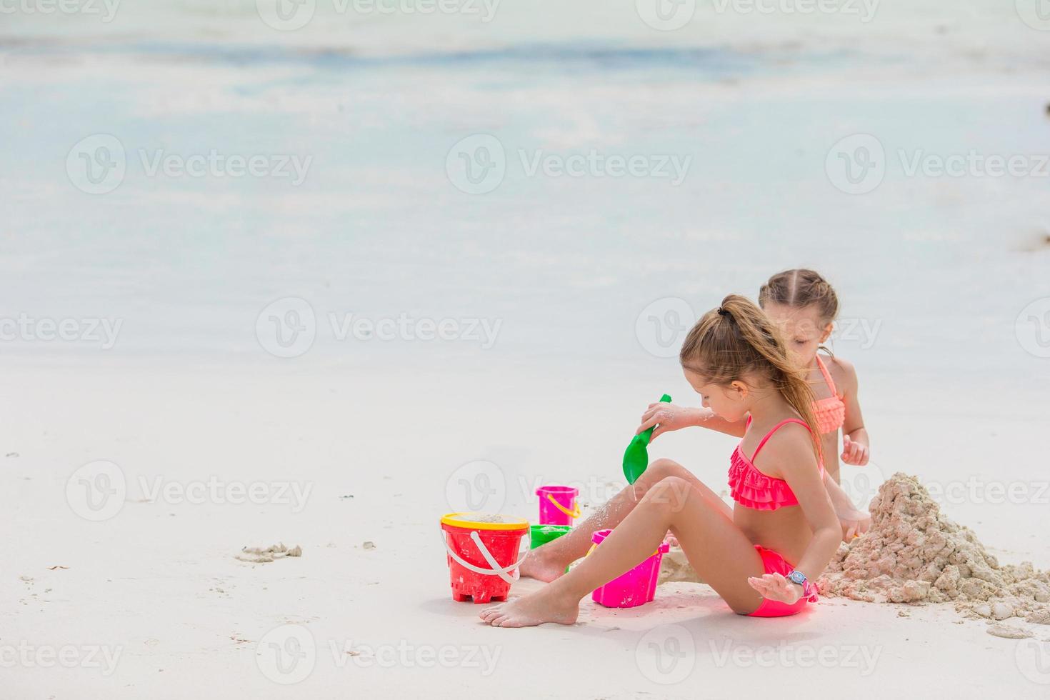 liten söt flickor spelar med strand leksaker under tropisk semester foto