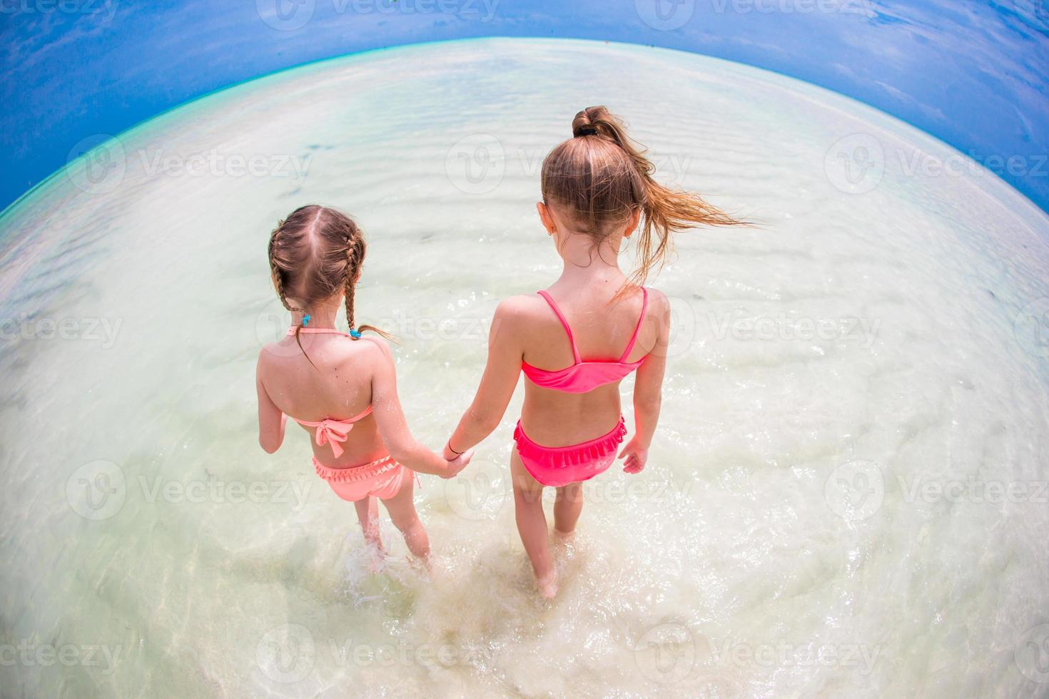 bedårande små flickor på stranden under sommarlovet foto