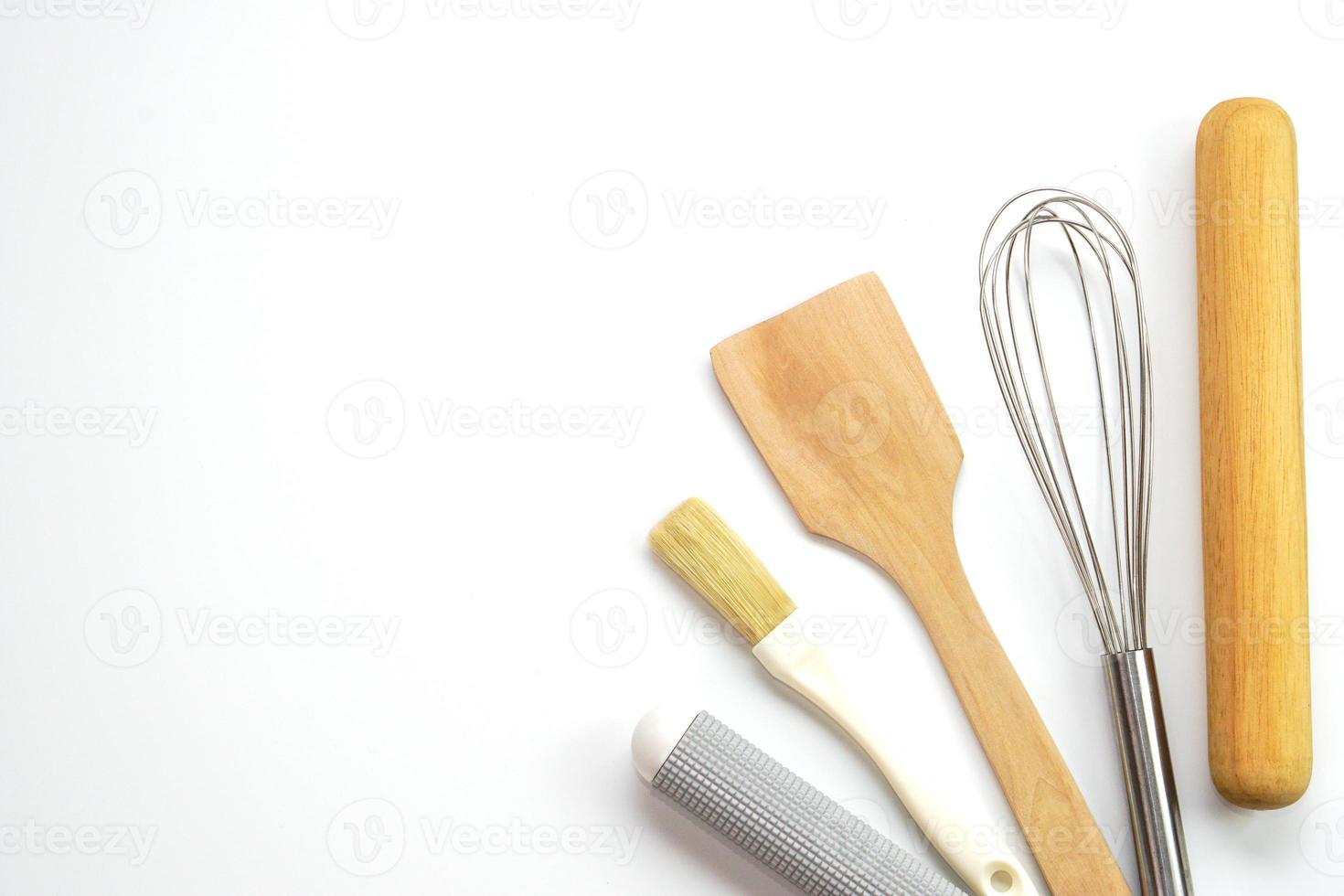 topp se köksutrustning trä- rullande stift, trä- spatel och ägg visp på vit bakgrund. material eller kök Utrustning för bageri. foto