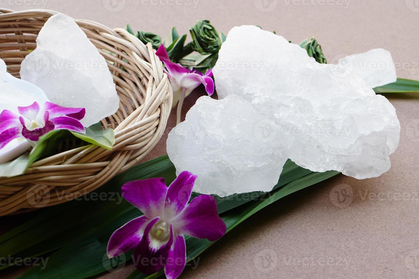 kristall klar alun stenar eller kalium alun dekorerad med blommor och löv. användbar för skönhet och spa behandling. använda sig av till behandla kropp odör under de armhålor som deodorant och göra vatten klar. foto