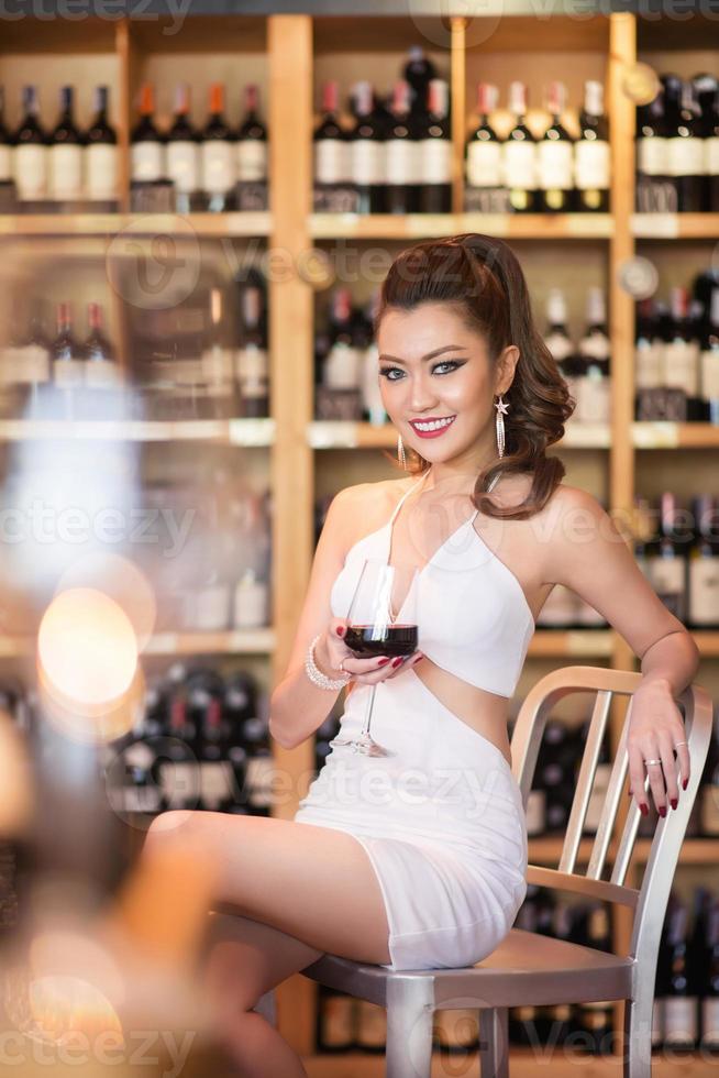 skön asiatisk kvinna med en glas av vin foto