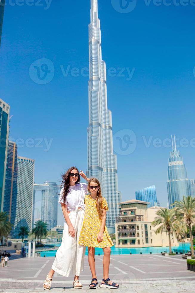 Lycklig familj gående i dubai med skyskrapor i de bakgrund. foto