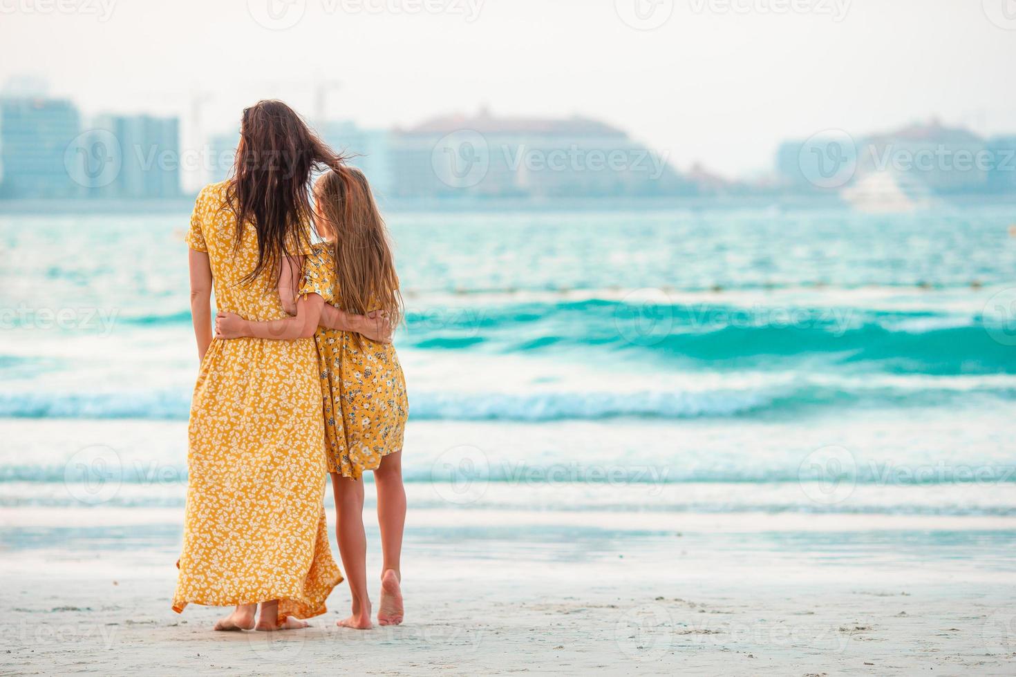 skön mor och dotter på de strand njuter sommar semester. foto