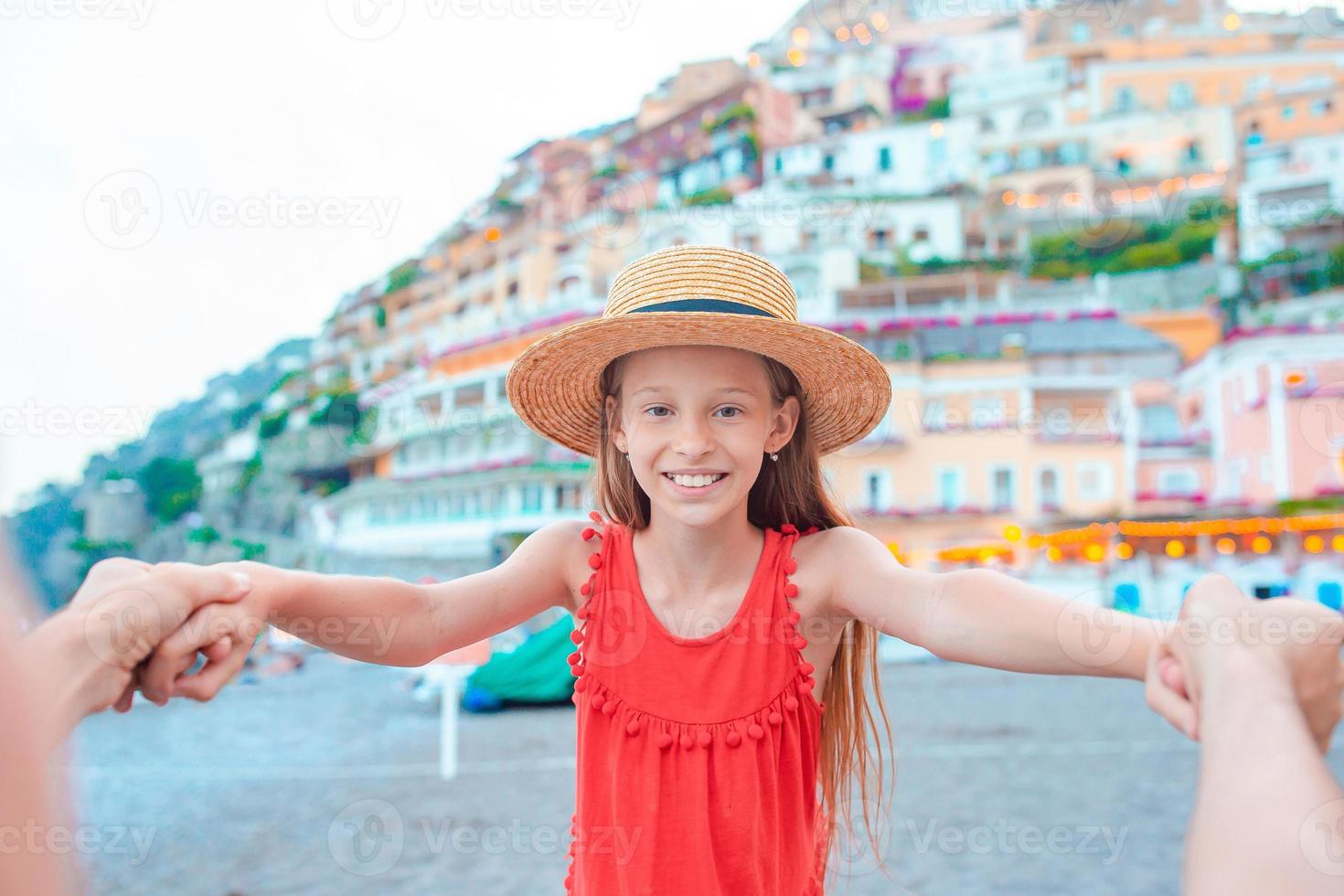 förtjusande liten flicka på värma och solig sommar dag i positano stad i Italien foto