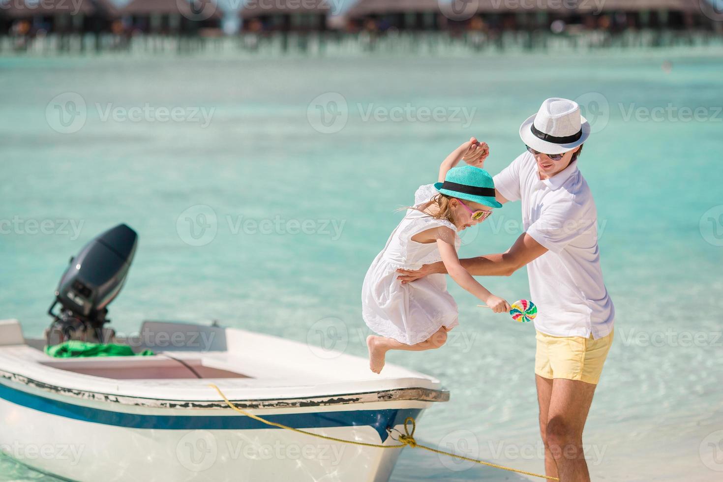 glad far och hans bedårande lilla dotter på tropisk strand har roligt foto
