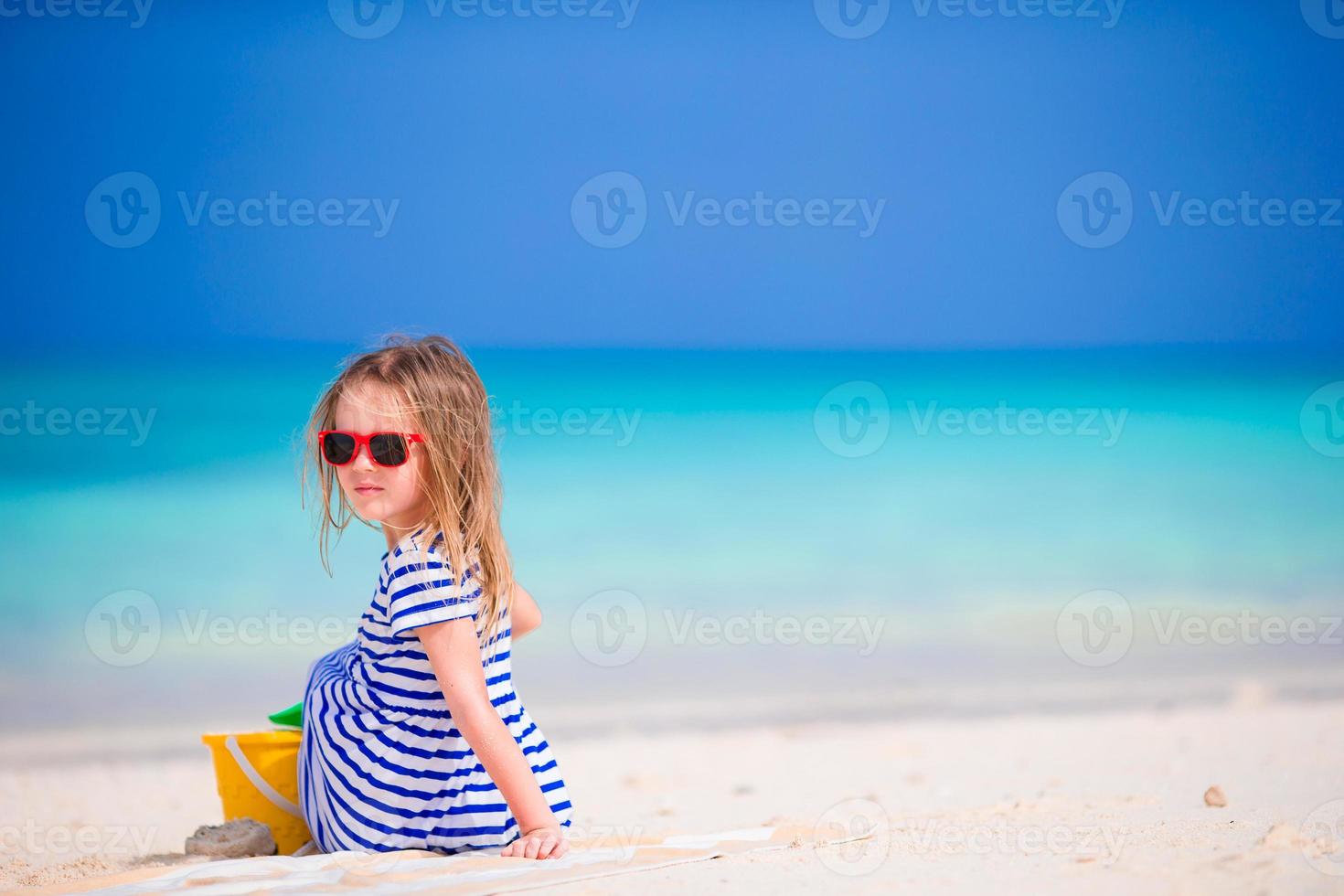 bedårande liten flicka som leker med strandleksaker under tropisk semester foto