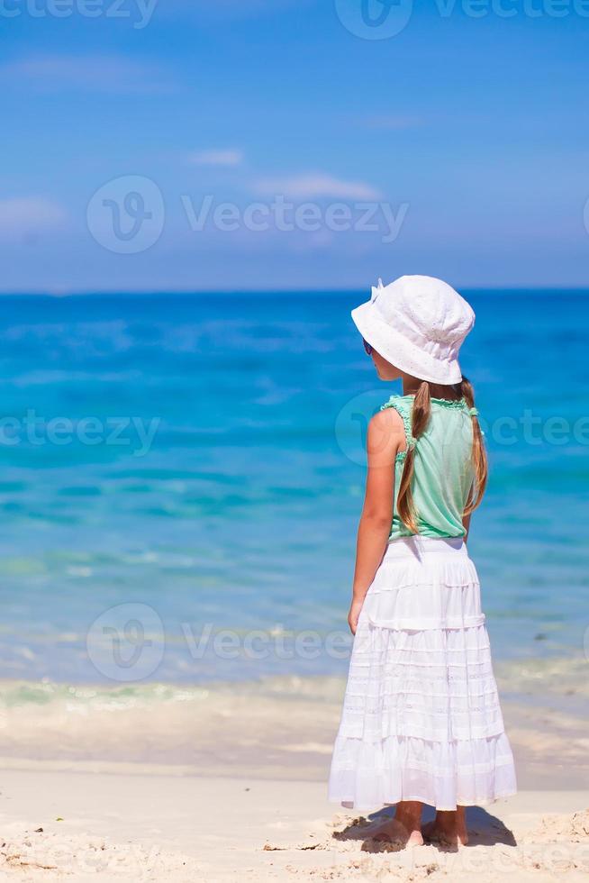 tillbaka se av förtjusande liten flicka på tropisk strand foto