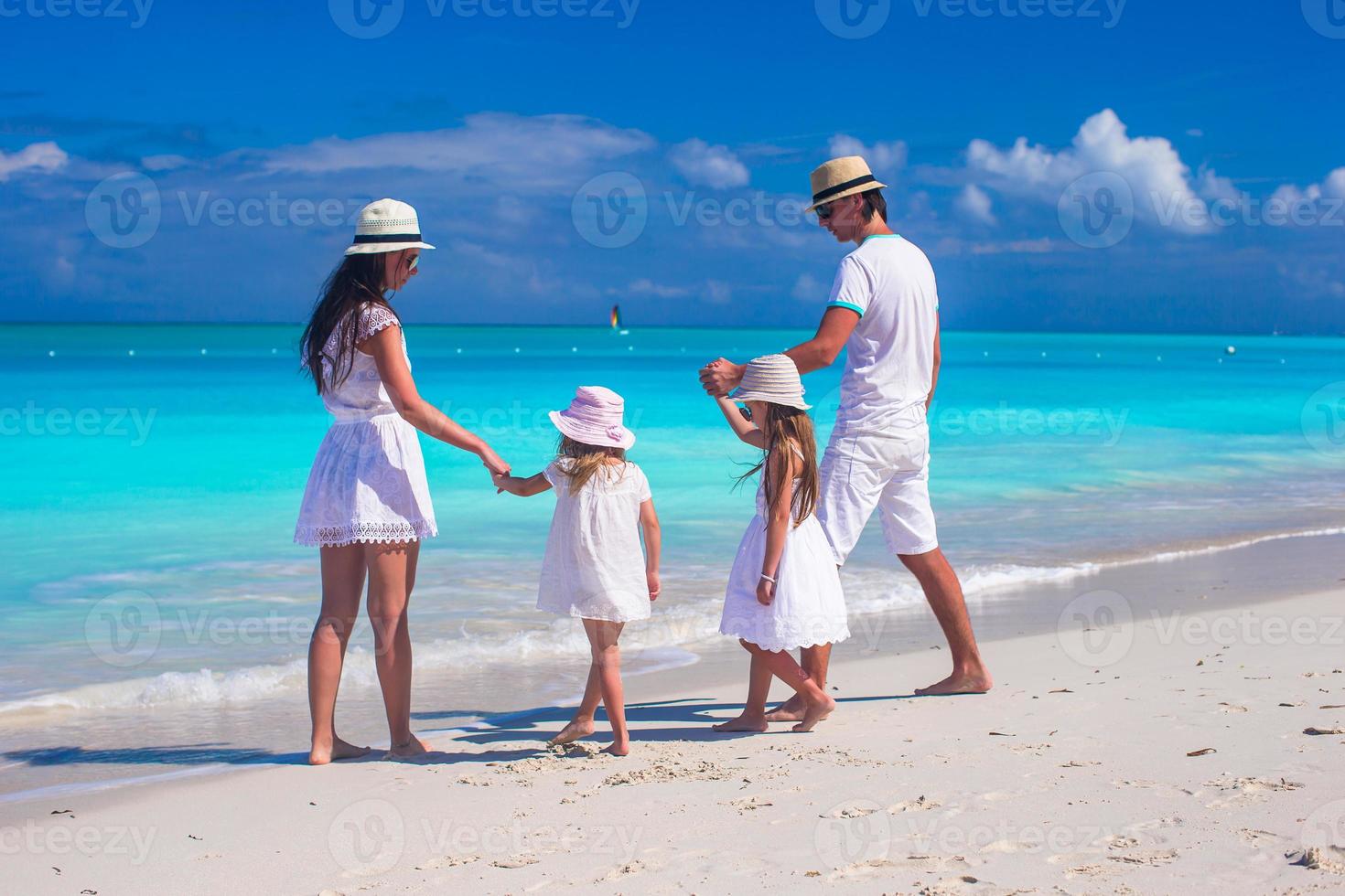 familj av fyra med två barn under strand sommar semester foto