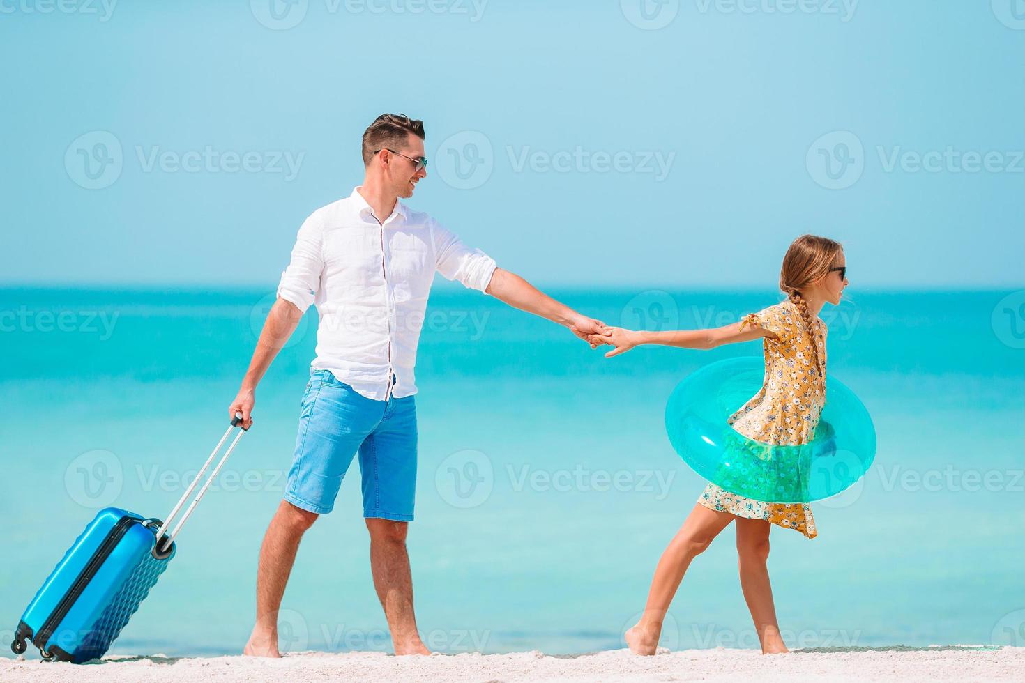 liten flicka och Lycklig pappa har roligt under strand semester foto