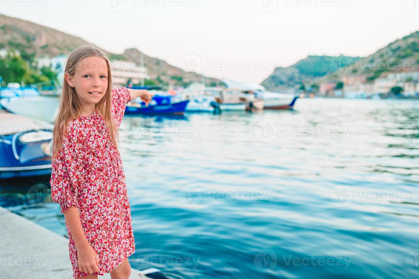 förtjusande liten flicka i hamn på sommar dag foto