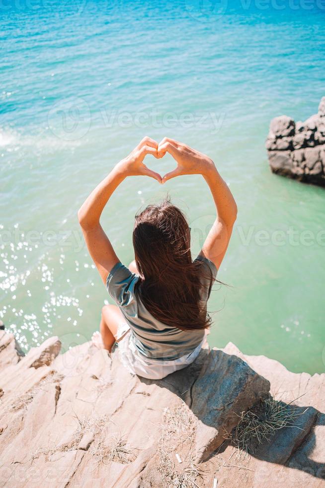 turist kvinna utomhus- på kant av klippa havsstrand foto