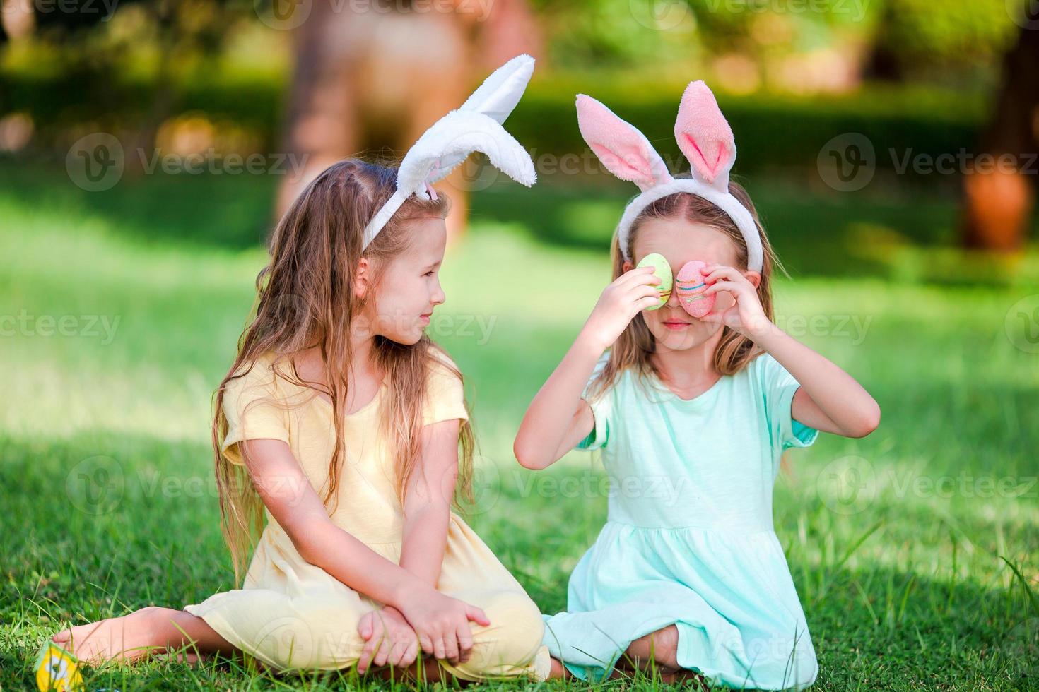 två liten flickor bär kanin öron på påsk utomhus foto