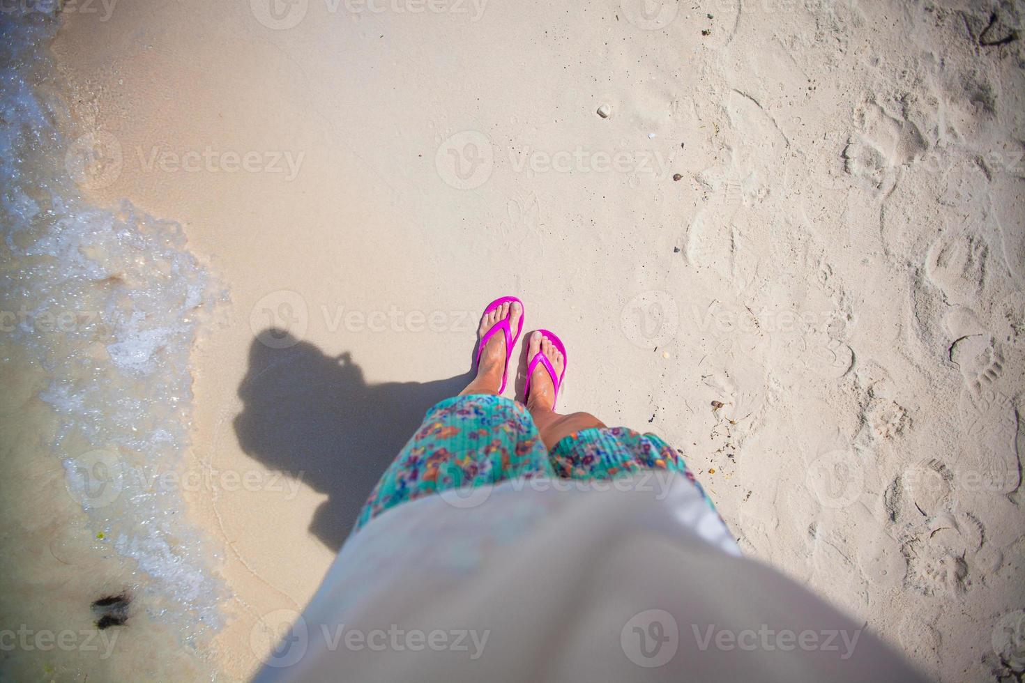 närbild av en kvinnas fot i de skiffer på sand strand foto