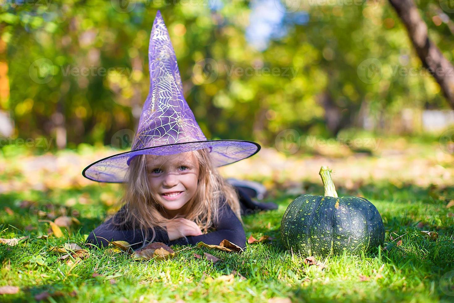 Lycklig liten flicka i halloween kostym med domkraft pumpa.trick eller behandla foto