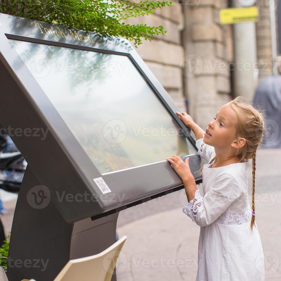 liten söt flicka ser de Karta av milan foto