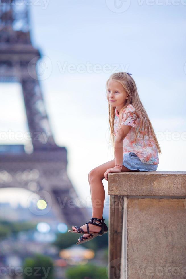 förtjusande liten flicka nära de eiffel torn under sommar semester i paris foto