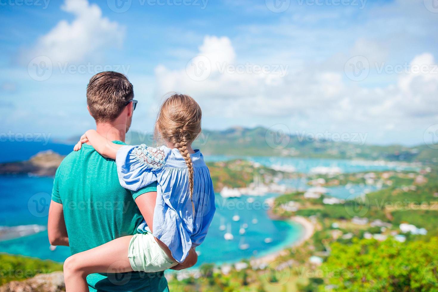 familj av pappa och liten unge njuter de se av pittoresk engelsk hamn på antigua i karibiska hav foto