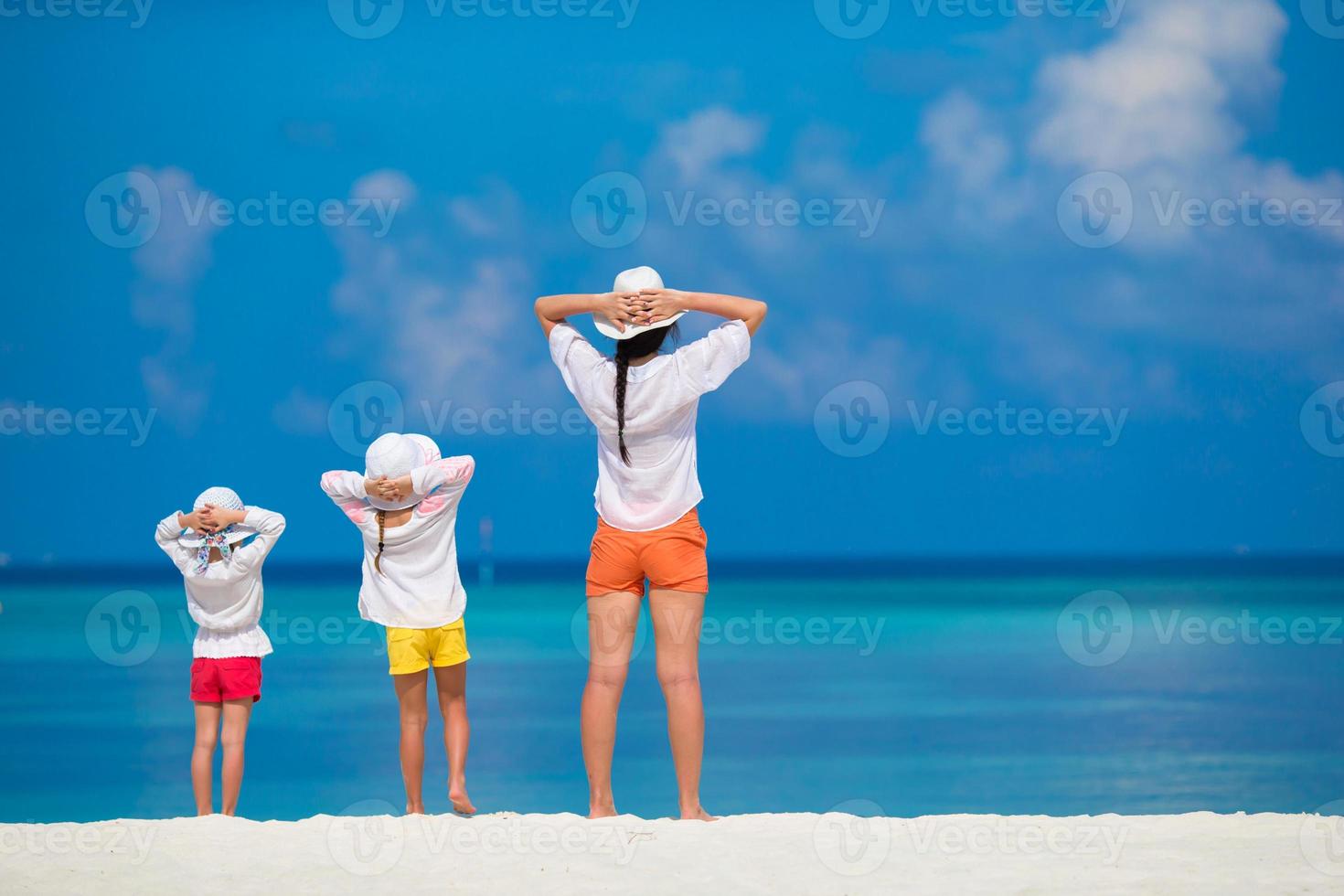 små flickor och mamma på den tropiska vita stranden foto