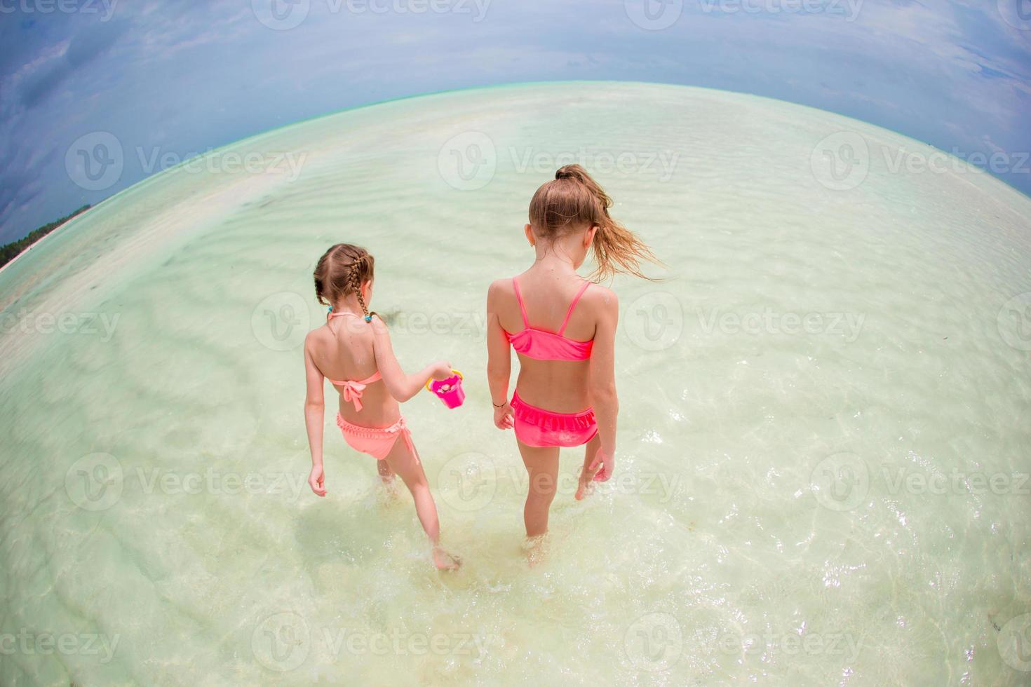 förtjusande liten flickor ha roligt på de strand foto