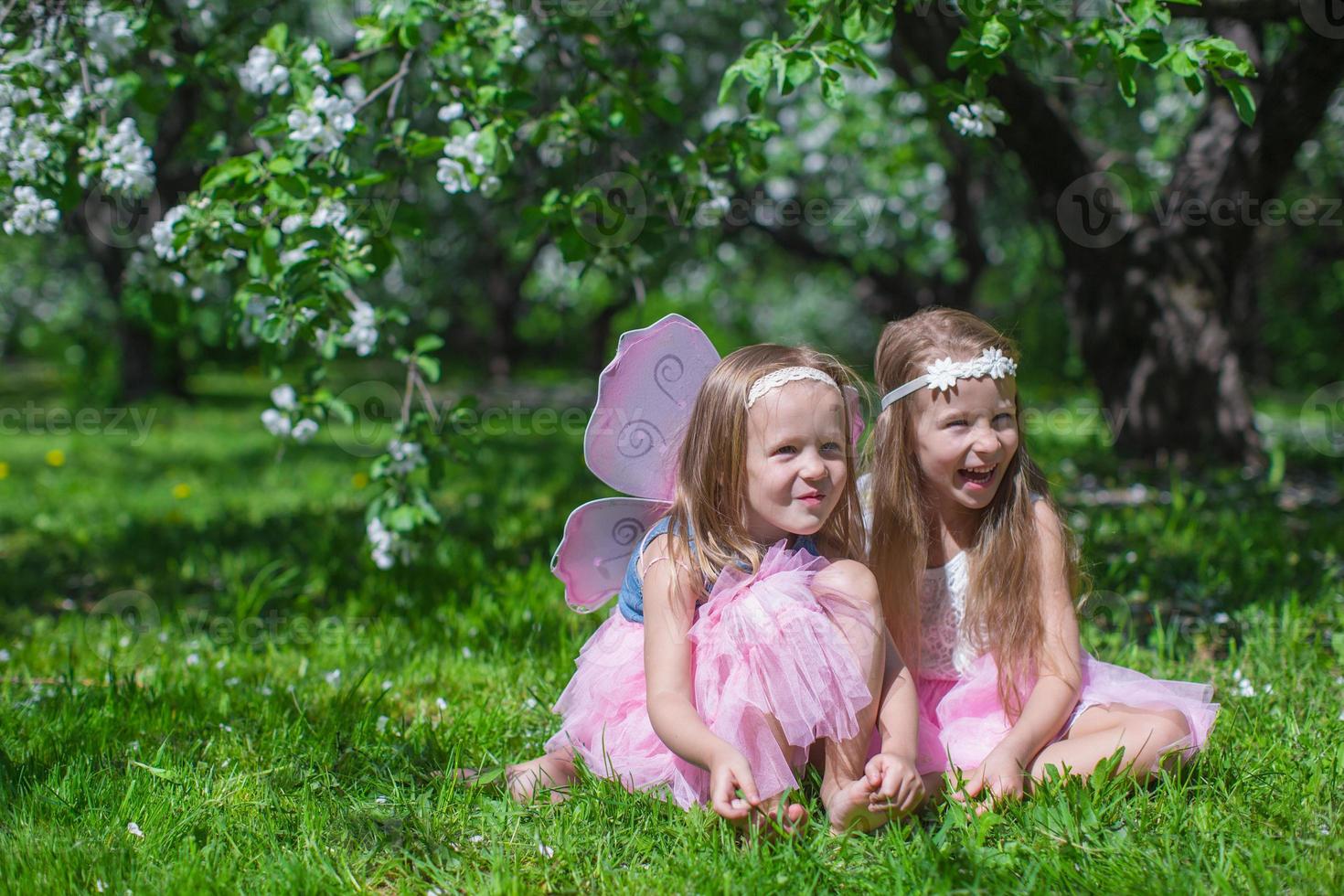 liten söt flickor i de blomstrande äpple trädgård foto