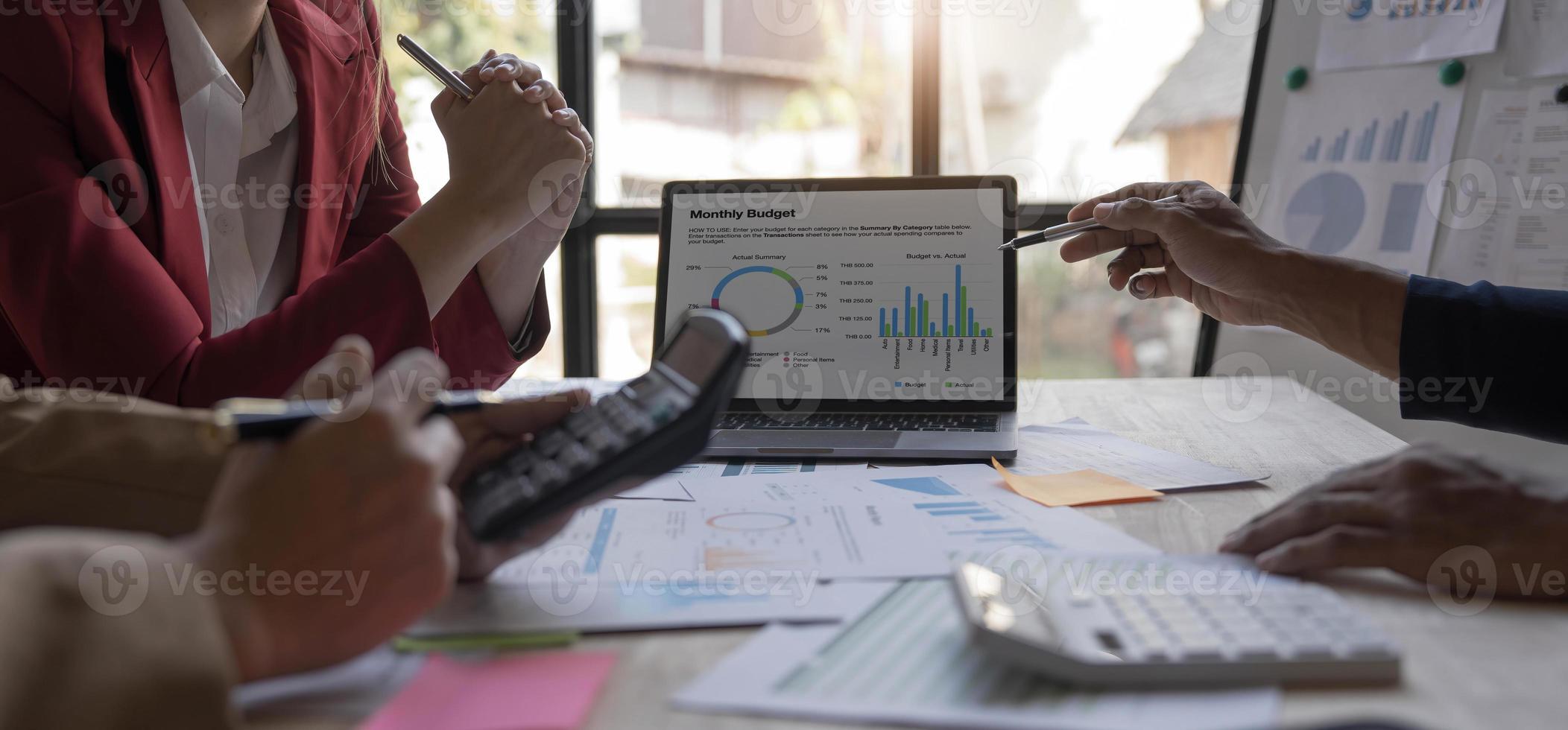 affärsmän möte med bärbar dator, kalkylator, anteckningsbok, aktiemarknadsdiagrampapper för analysplaner för att förbättra kvaliteten nästa månad. konferens diskussion företagskoncept foto