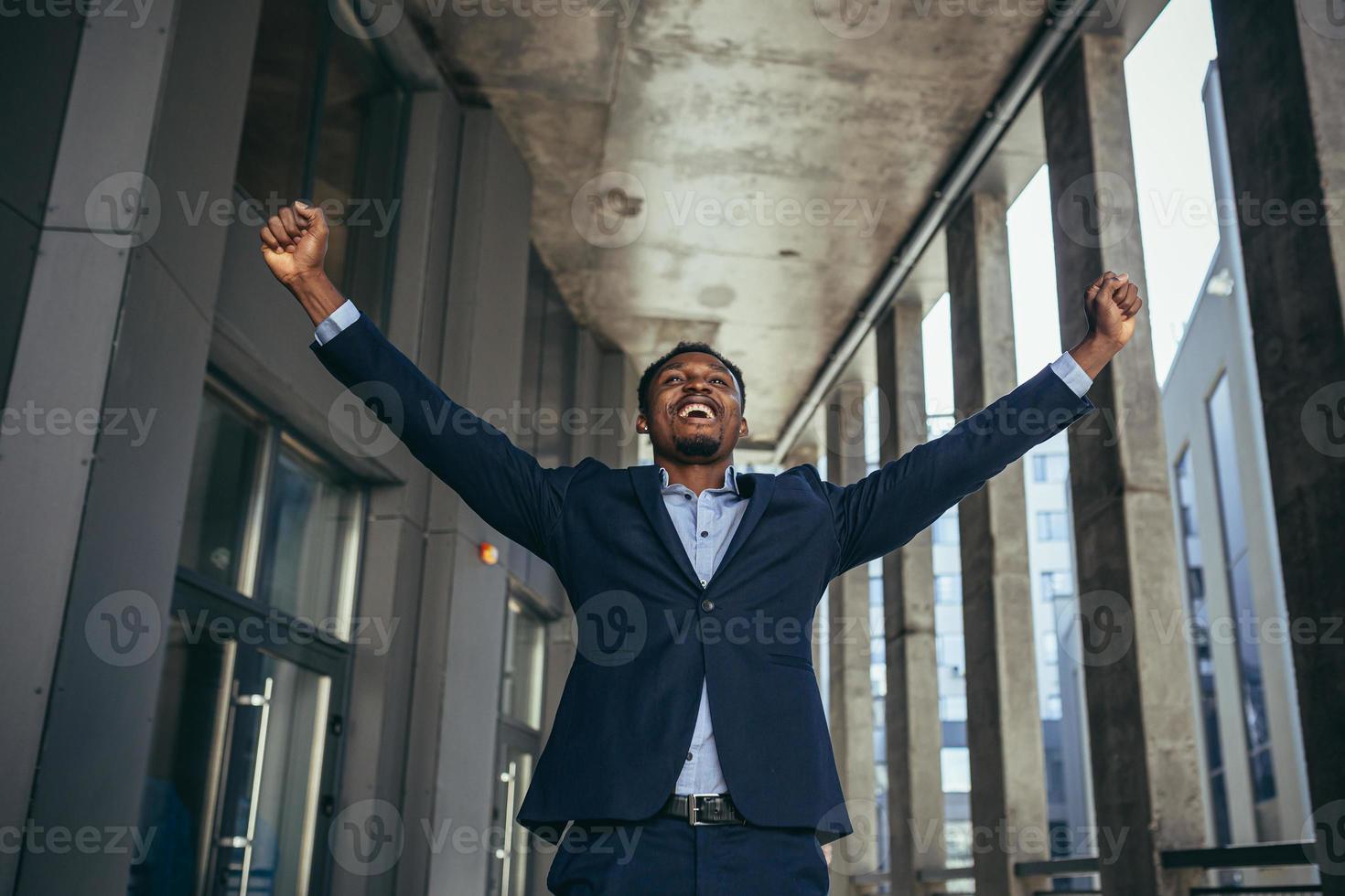 upphetsad afrikansk amerikan affärsman gläds i seger ser på kamera foto