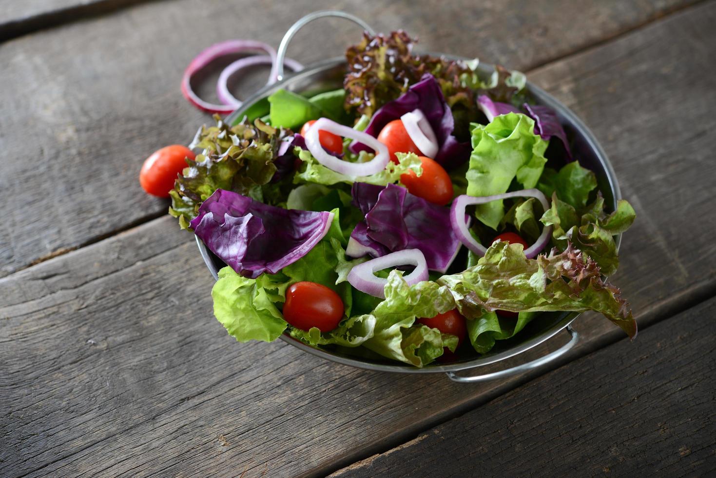 färsk grönsaksallad med rustik gammal träbakgrund foto