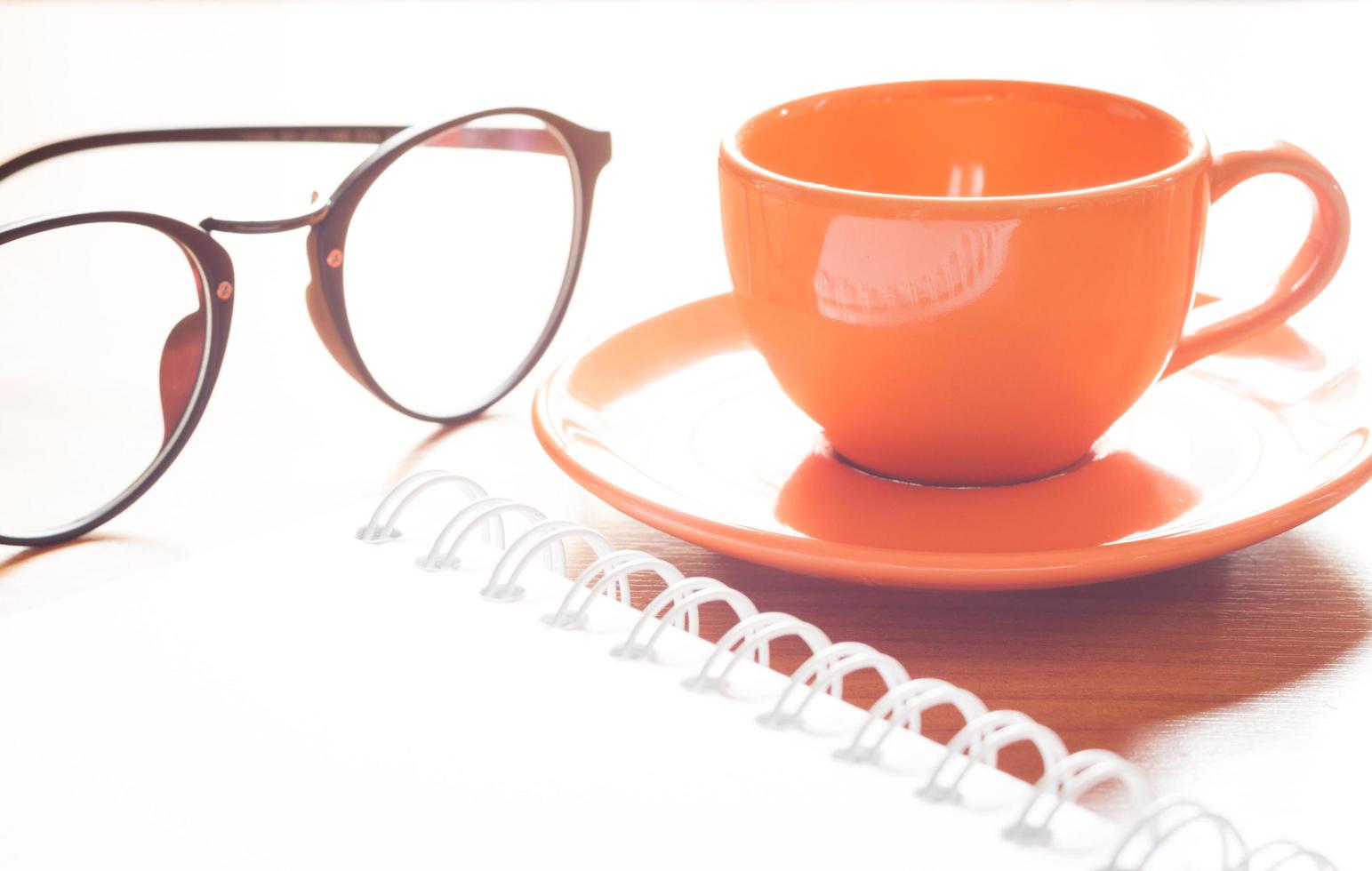 närbild av en kaffekopp och glasögon foto