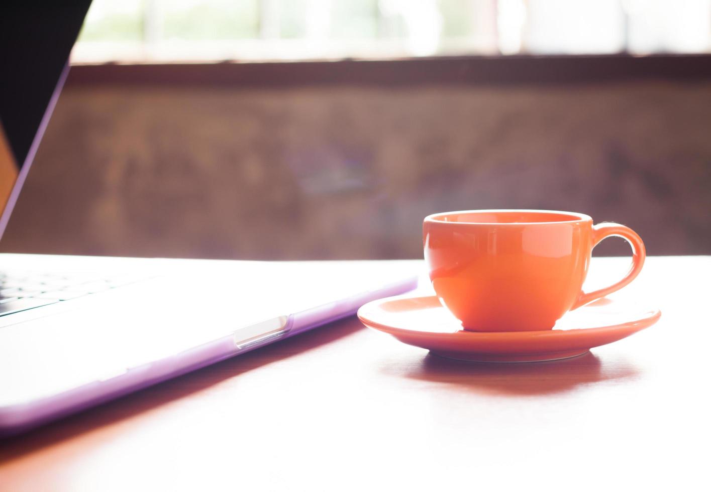 kaffekopp bredvid en bärbar dator foto