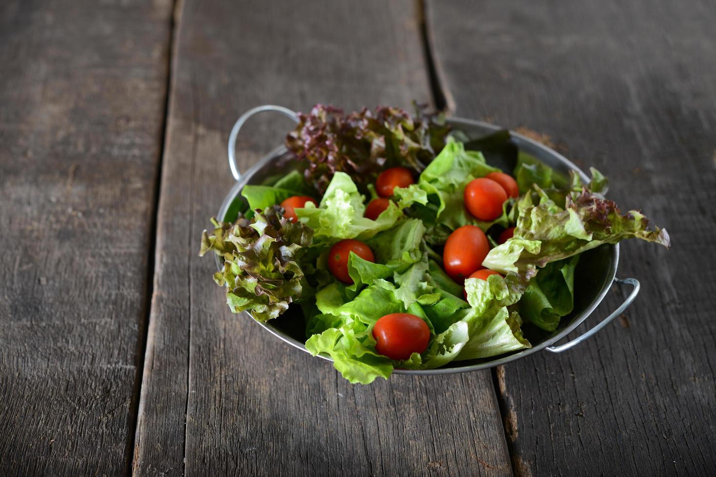 färsk grönsaksallad med rustik gammal träbakgrund foto